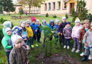 Dzieci pozują przy zasadzonym drzewku